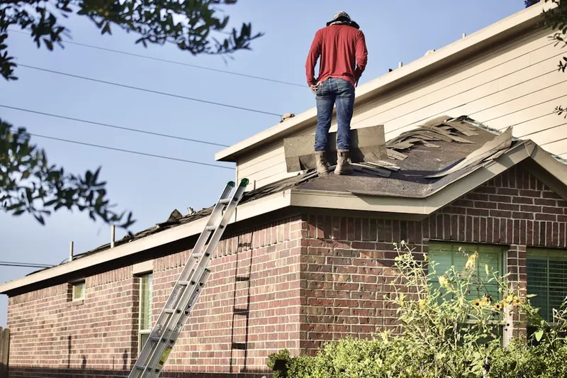 Professional roofer working on a residential roof in Newton Heights